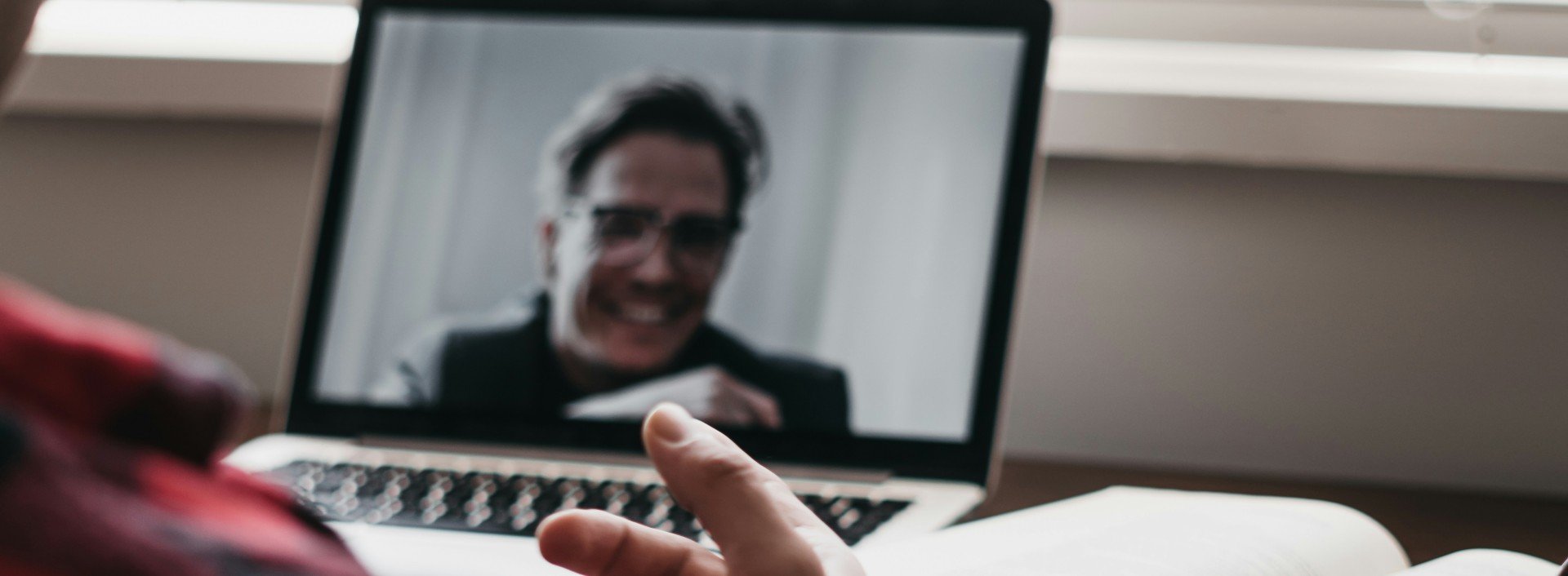 Two people talk to each other in a video conference.