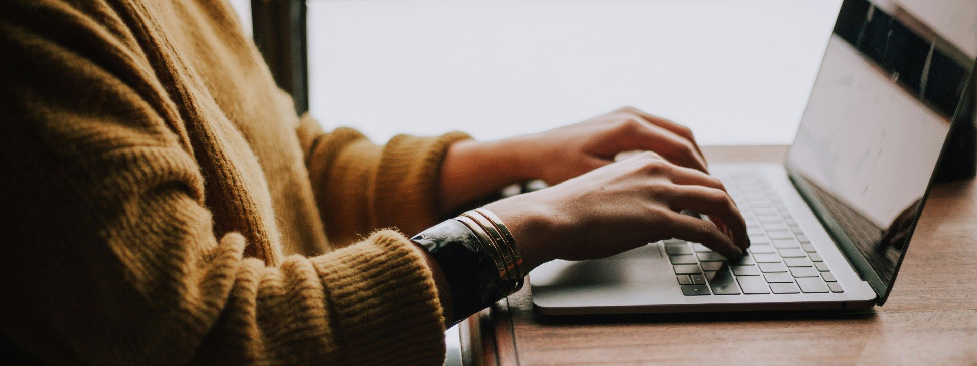 Vocabulary for Microsoft Word: a woman in a yellow sweater writes on a computer in Microsoft Word.