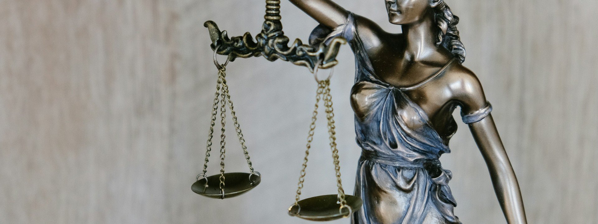 Legal Doublets in English: a bronze statue of the the goddess Justice is shown holding scales.